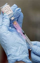 يد ممارس صحي يسحب اللقاح للحقنة