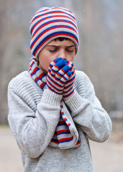 a boy feeling cold and warming his hands