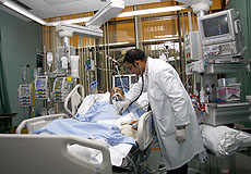 a doctor standing by a patient bed in the ICU