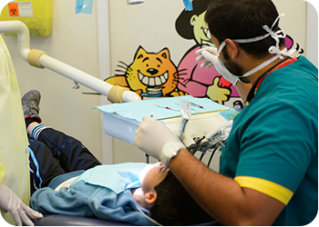 dentist examine a child in one of School Dental Prevention Program visits